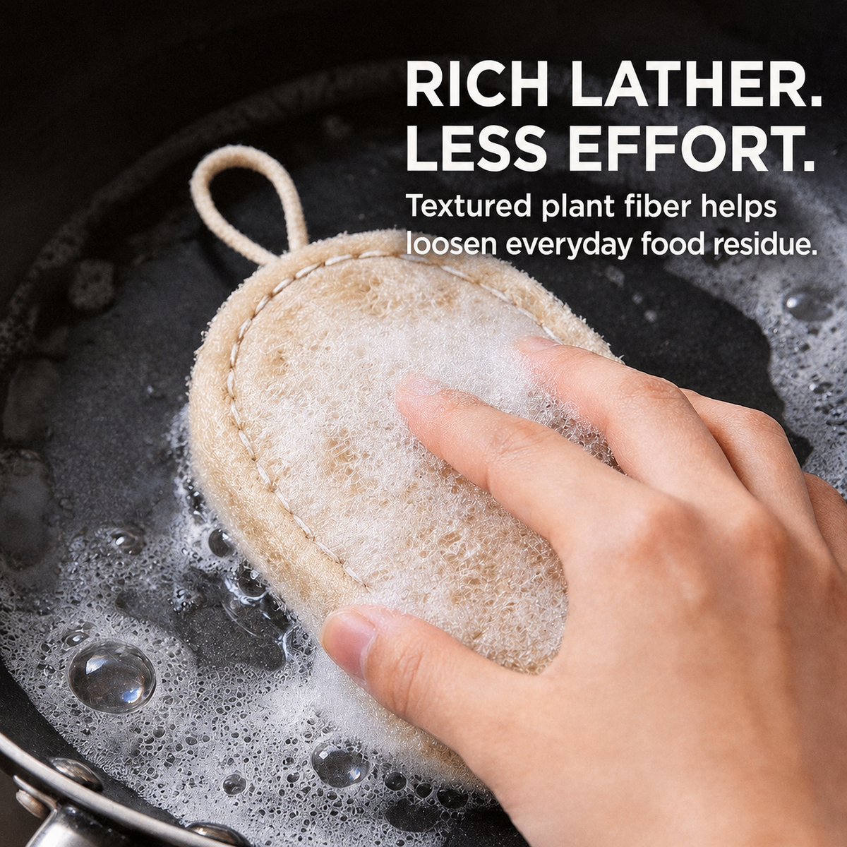 Natural loofah dish scrubber creating rich lather in a pan