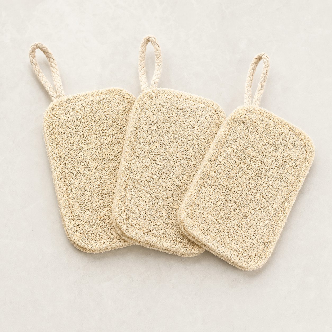 Three natural loofah dish scrubber pads with hanging loops